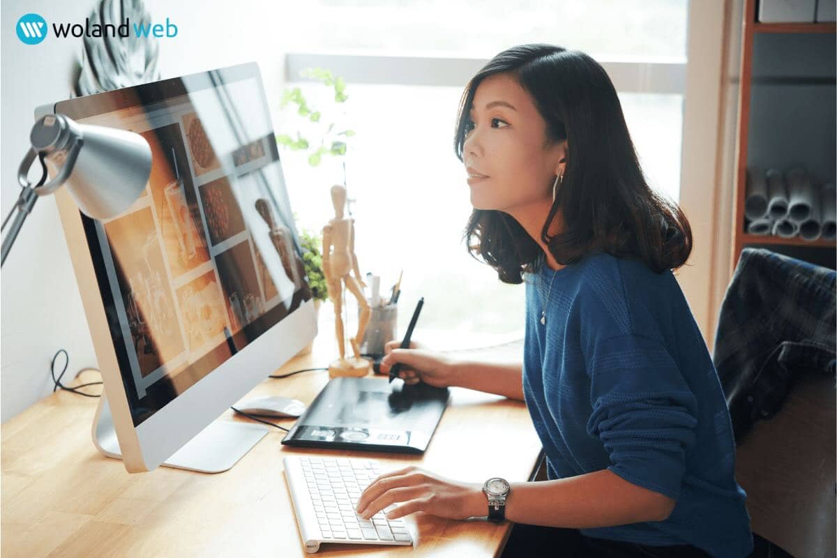 woman in blue sweater working on a computer