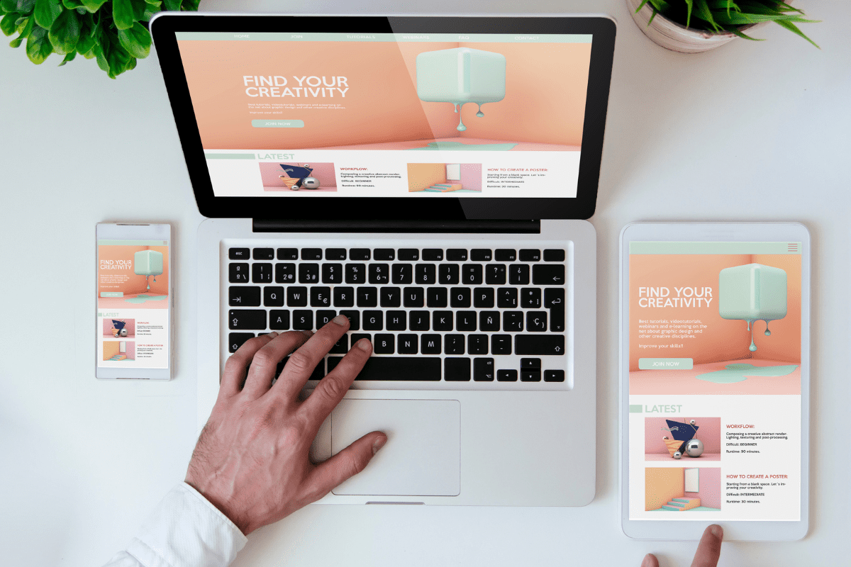desk with laptop, phone and tablet showing the same website on all 3 showing a responsive website