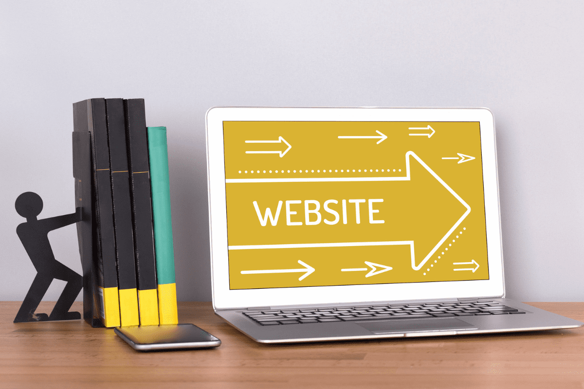 table with laptop, laptop screen showing yellow background with arrows and the word