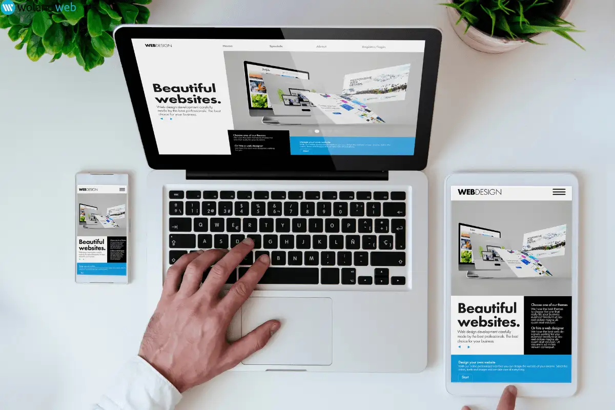 website shown on laptop, desktop and mobile phone with hand typing on laptop