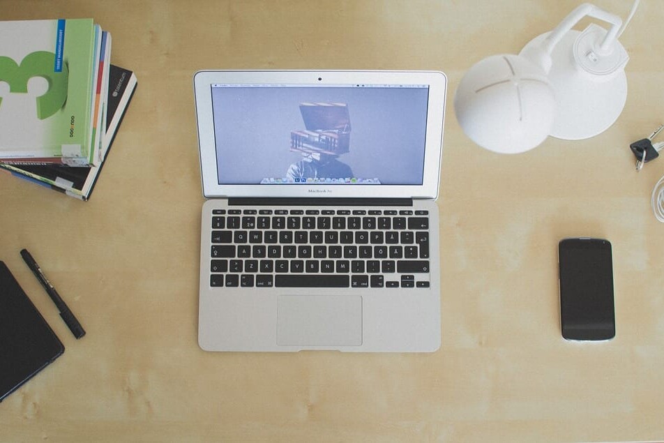 desk with laptop, book and mobile phone