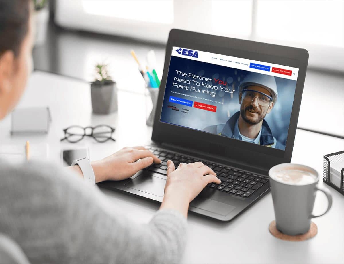 person at desk with coffee and laptop looking at the ESA website
