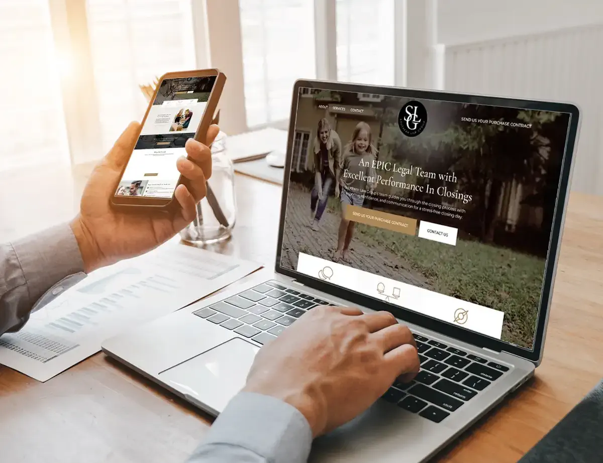 man looking at law firm website on mobile phone and laptop